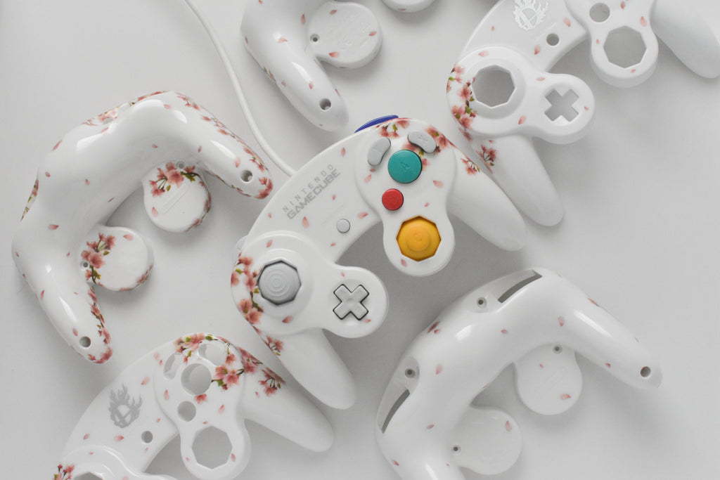 assortment of custom gamecube controllers with varying floral and cherry blossom design #customgcc #customgamecube #customgamecubecontroller #customcontroller #supersmashbros #supersmashbrosmelee #supersmashbrosultimate